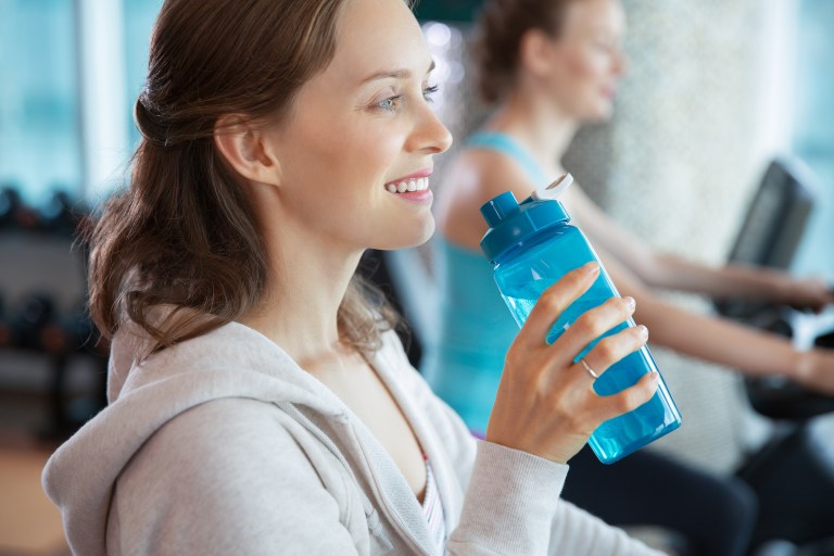 Smiling Woman Drinking Water While Training in Gym | Lo Scopribenessere