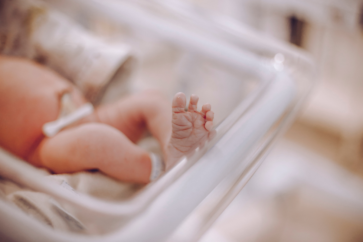 immagini per articoli 6 | Lo Scopribenessere Close-up of a newborn baby's tiny foot resting in a hospital bassinet.